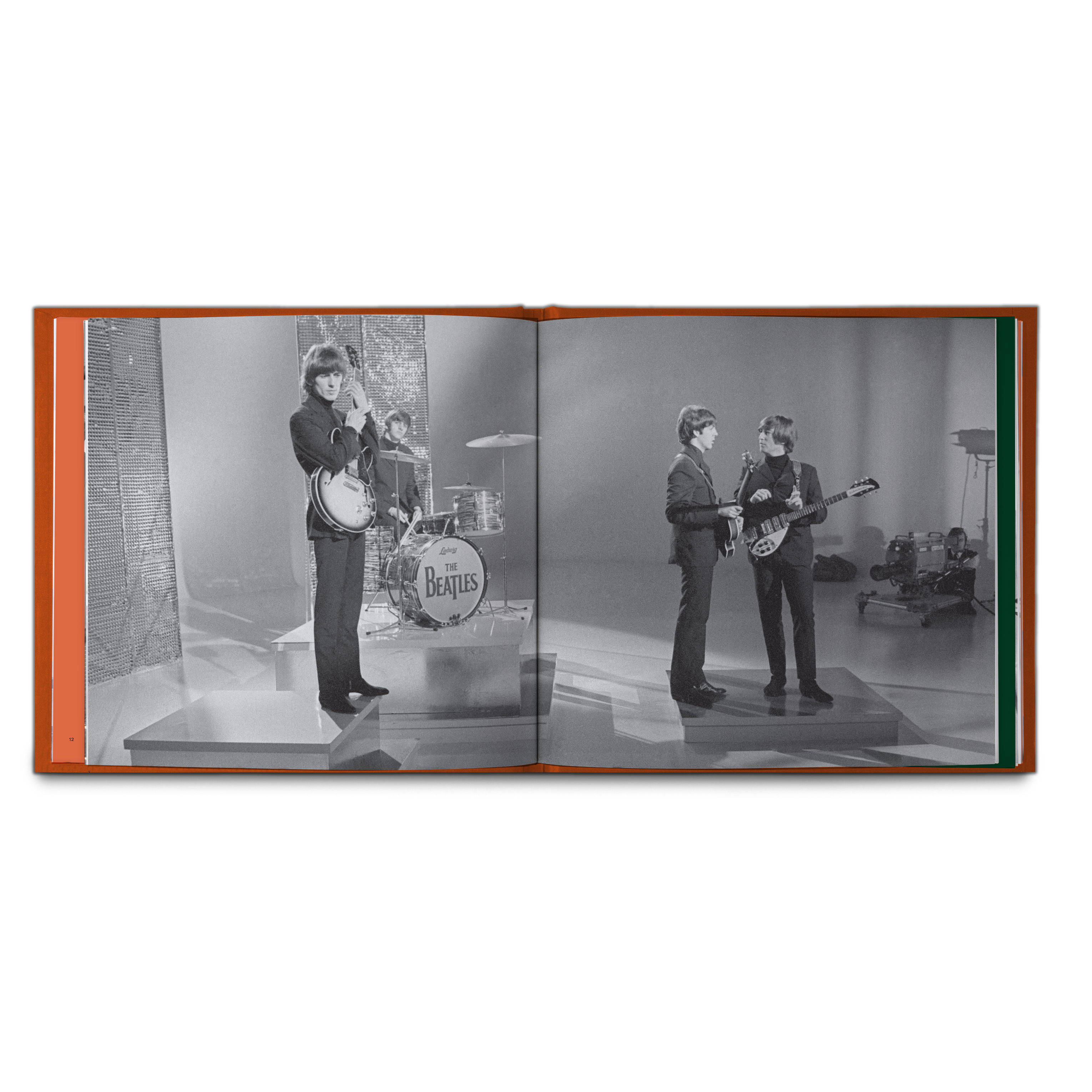 An open book or photo album showing a black-and-white printed photograph of The Beatles performing on stage, photographed against a plain white background. The Book that is included in the 5LP Box Set Exclsuive