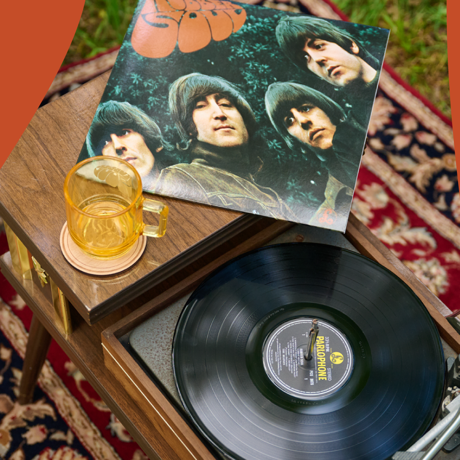 Rubber Soul Vinyl on a wooden turntable resting on top, alongside the Rubber Soul Japanese Glass Mug set on a patterned rug outdoors.